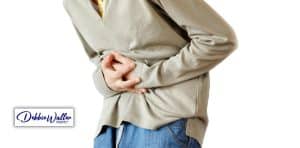 a man doubled over with stomach pain to illustrate an article on hypnotherapy and ibs