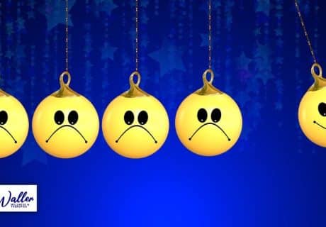 newton's cradle of balls with smiley faces, some looking negative and some positive to illustrate an article on breaking the cycle of negative thinking