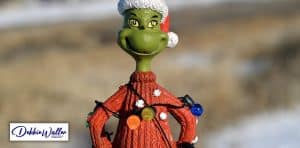 an image of the grinch wrapped in christmas lights to illustrate an article on social anxiety at christmas