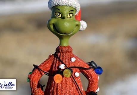 an image of the grinch wrapped in christmas lights to illustrate an article on social anxiety at christmas