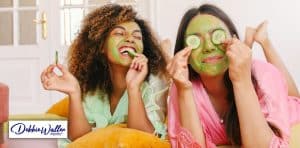 image of two friends laughing and wearing face masks to illustrate an article on self-care