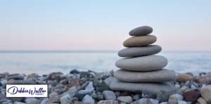 image of a seaside with stacked pebbles to illustrate an article on self hypnosis