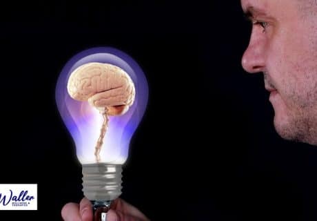 man looking at a brain in a light bulb, to illustrate an article on does hypnotherapy work