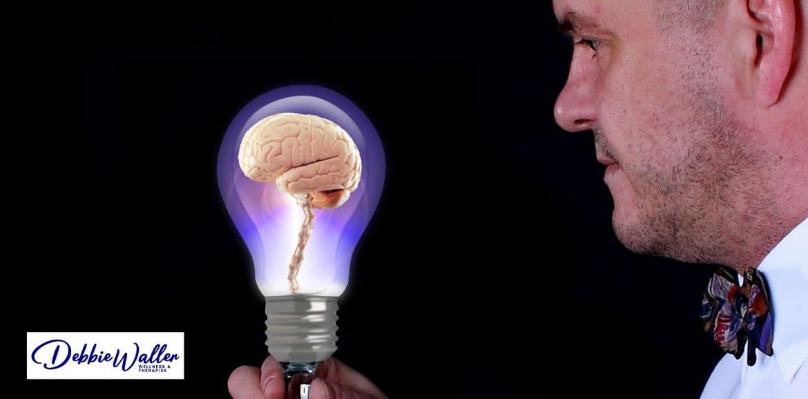 man looking at a brain in a light bulb, to illustrate an article on does hypnotherapy work