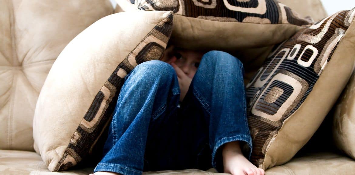 therapy for phobias and fears, image of girl hiding behind cushions